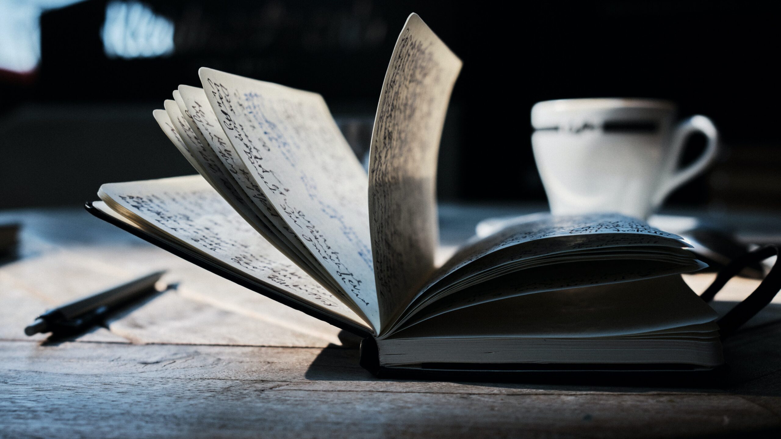 Open notebook with handwritten notes on a wooden table, representing ministry planning and content strategy